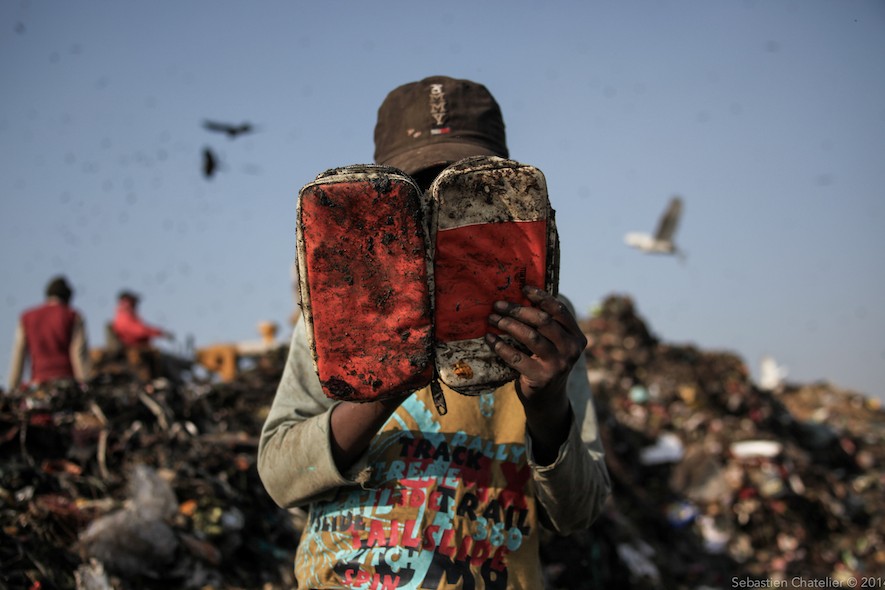 Education of Worker in Trash Mountain - New Delhi. This child has just discovered a dream object: a pencil case. An object that resonates as a mirage for these children who are uneducated. Several NGOs have tried to deliver free education to the children from the site at various locations, but they have had very limited results as the children’s priority is their work. (Photo: Sebastien Chatelier)