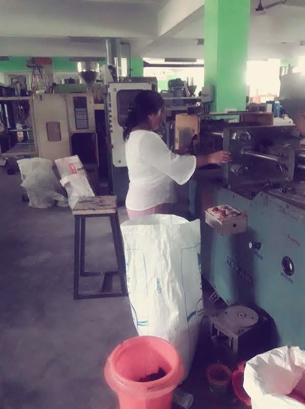 Ibapynhunshisha Kharnaior operating a plastics manufacturing machine